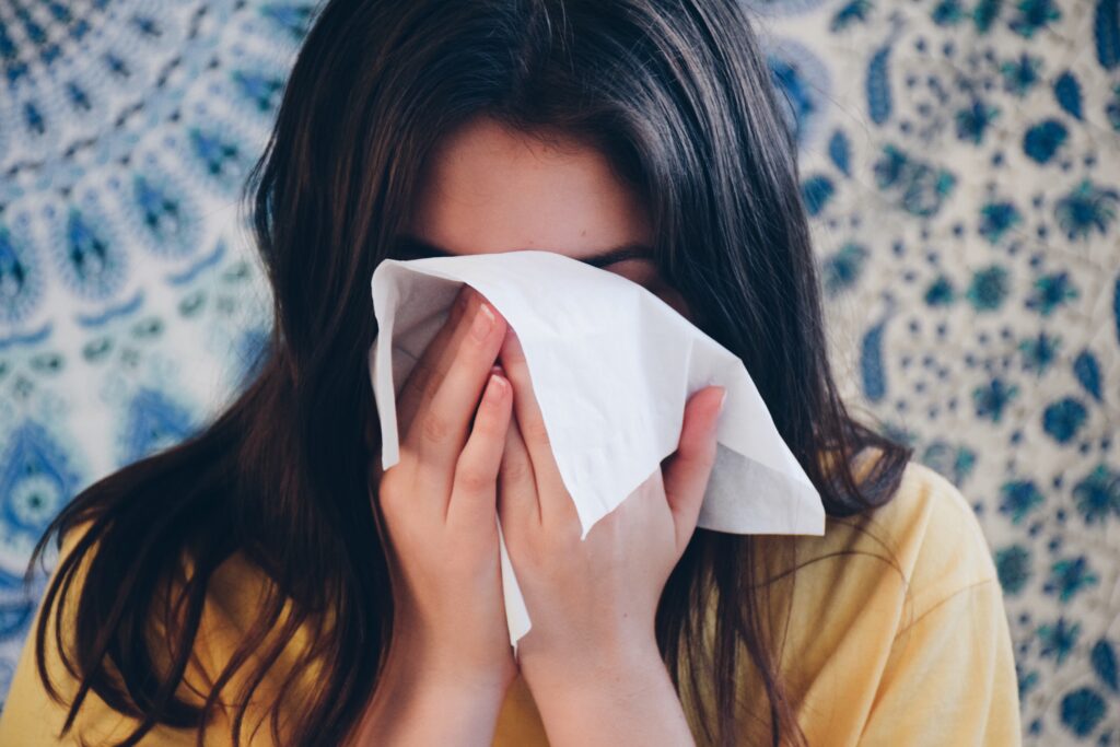 Woman sneezing in tissue