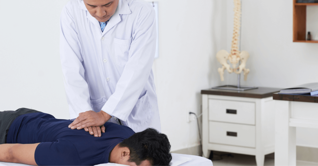 Chiropractor adjusting spine of male patient