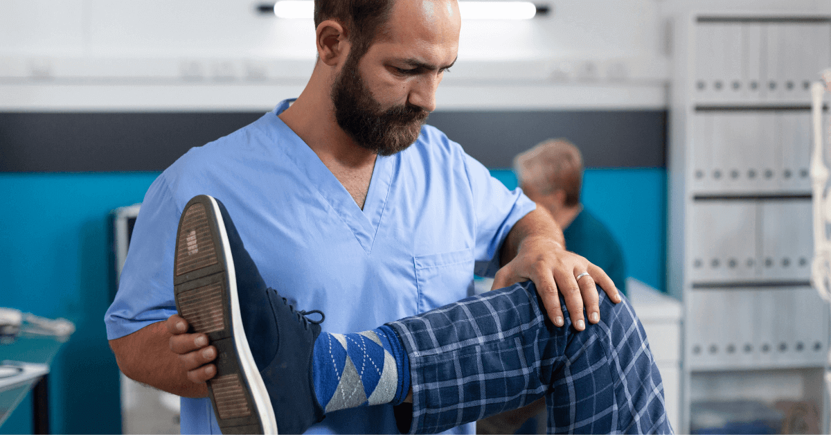 Chiropractor stretching leg of patient for range of motion